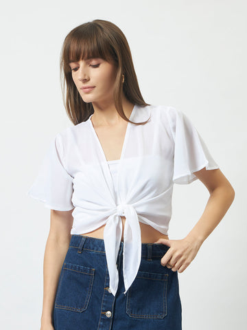 An off-white waterfall crop shrug worn open — the most versatile layering piece in the wardrobe